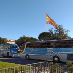 Dos autocares de Rubimar aparcados junto a edificio con bandera de España